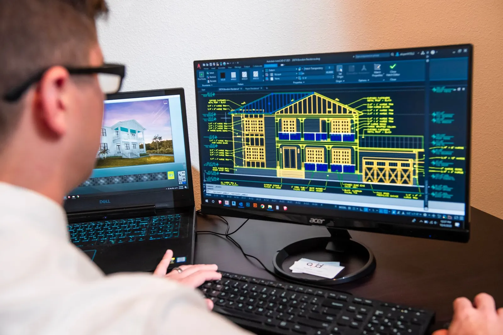 Engineer working on building drawings across two screens