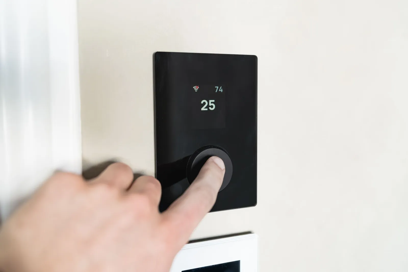 Hand adjusting a smart building control panel